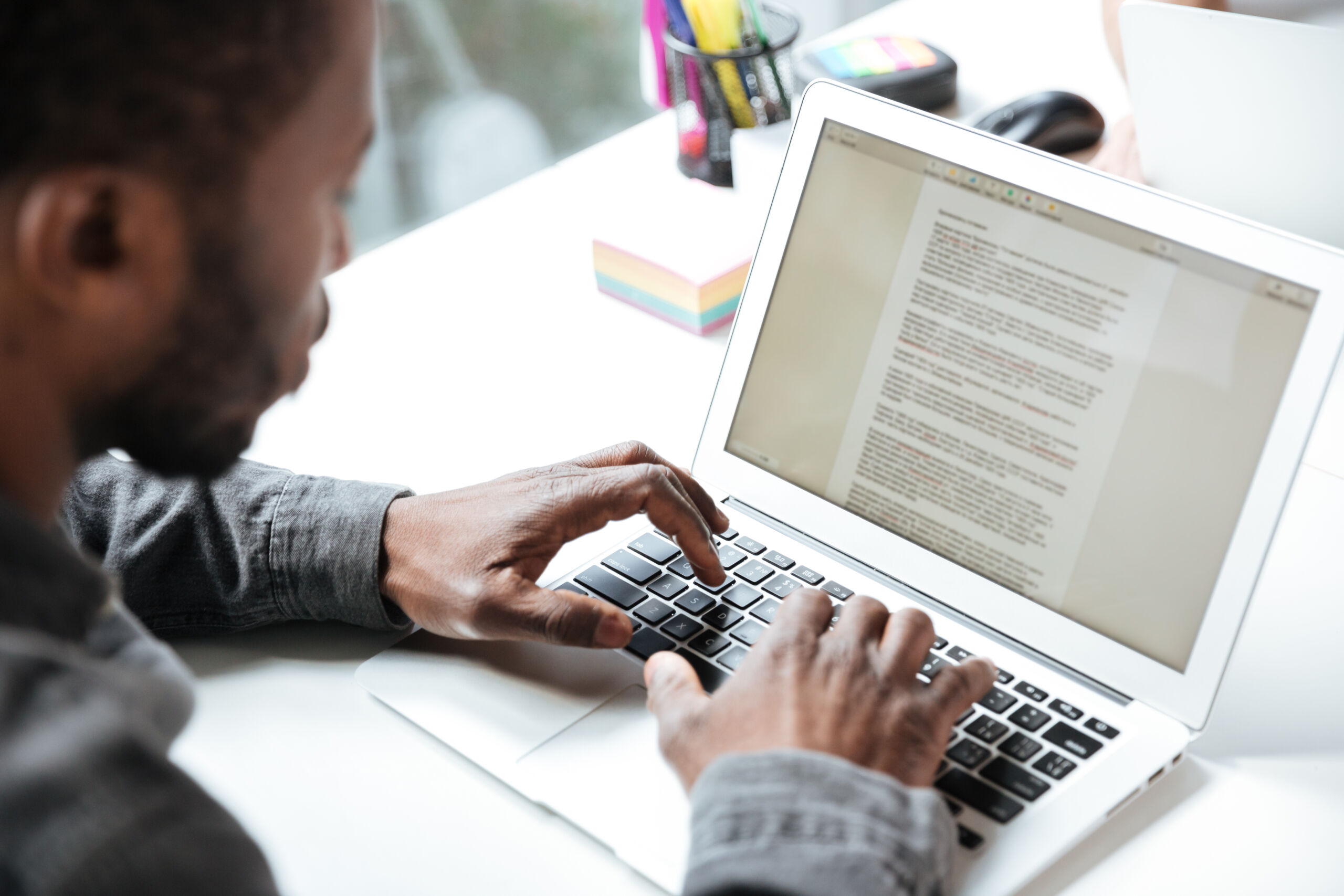 How to delete a page in Word? A man sitting at a computer with an open text editor.